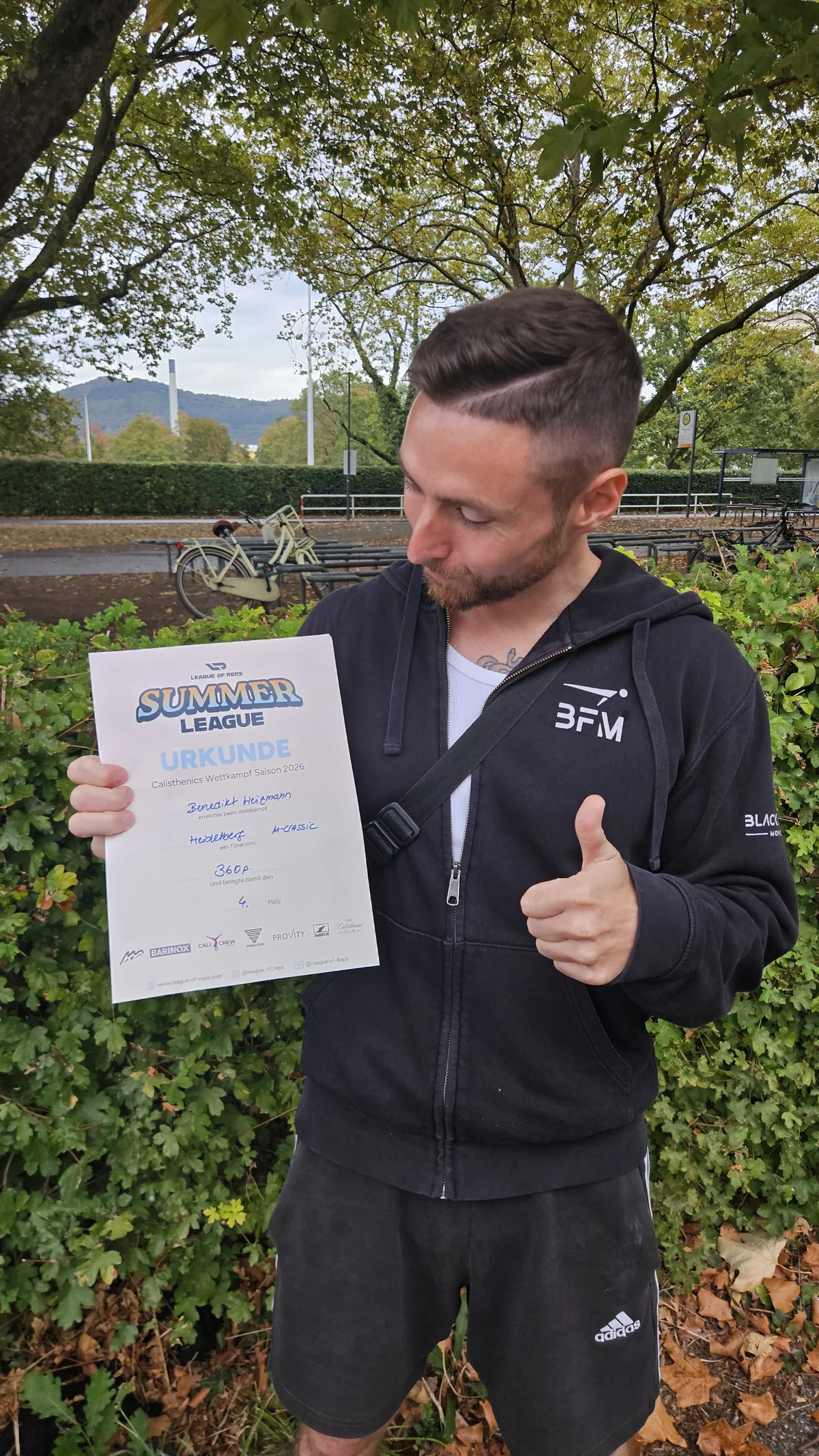 Benedikt Heizmann mit Daumen hoch und Urkunde nach seinem 4. Platz bei der League of Reps in Heidelberg